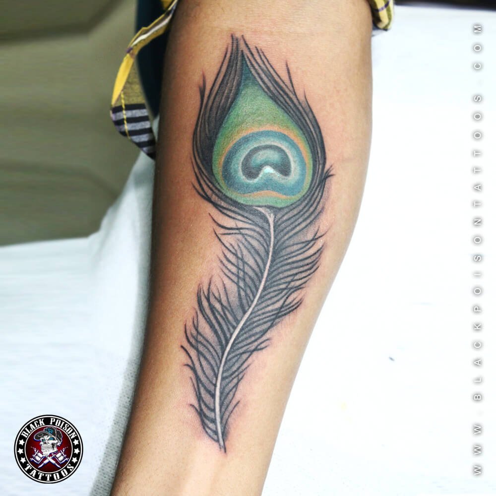 Peacock feather tattoo locatewd on the inner forearm.