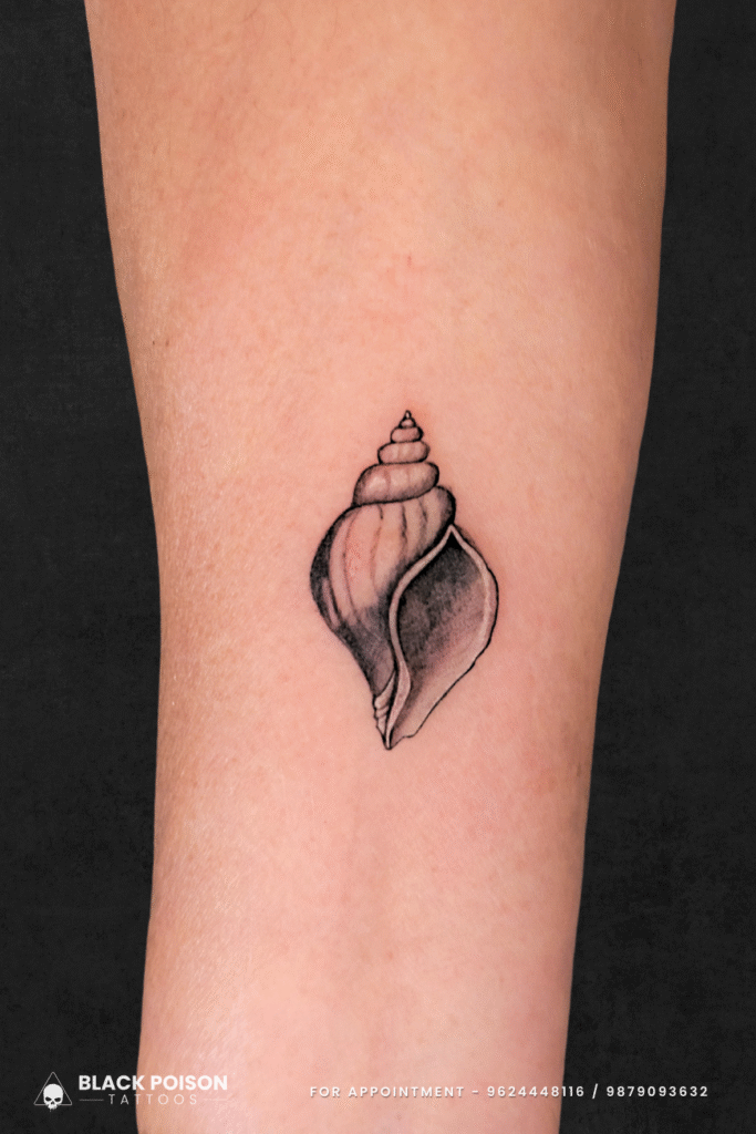 Minimalist conch shell tattoo on forearm symbolizing spiritual power and protection