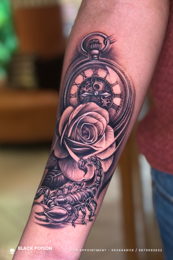 Black and grey realism tattoo of a pocket watch, blooming rose, and realistic scorpion on a forearm done at Black Poison Tattoos Ahmedabad.
