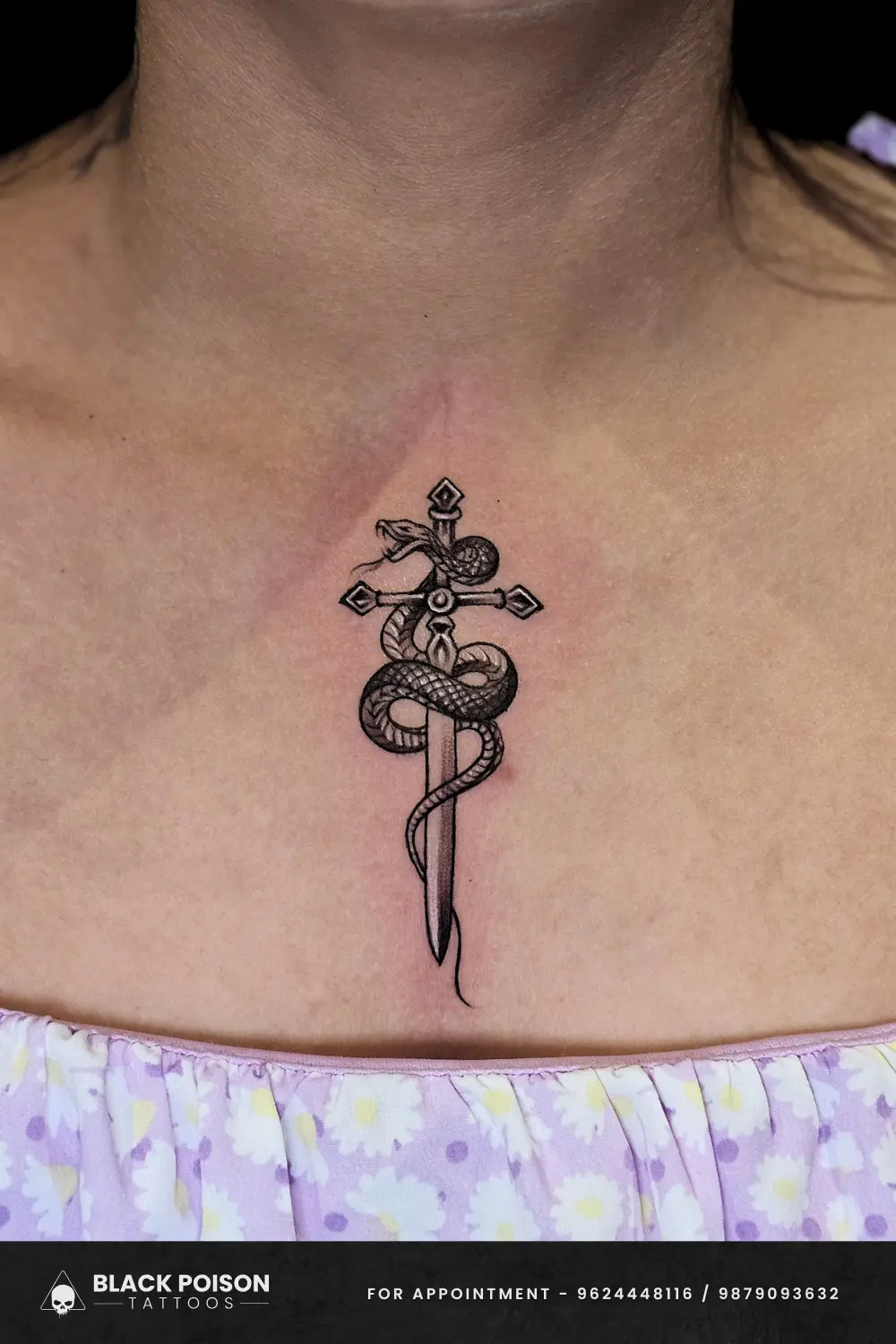 Black and grey illustrative snake coiled around a dagger tattoo on a woman's sternum, done at Black Poison Tattoos in Ahmedabad.