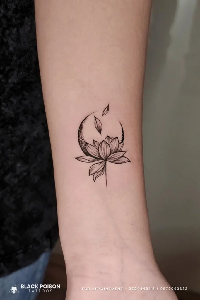 Delicate fine line minimalist lotus flower and stippled crescent moon tattoo on the inner forearm, done at Black Poison Tattoos in Ahmedabad.
