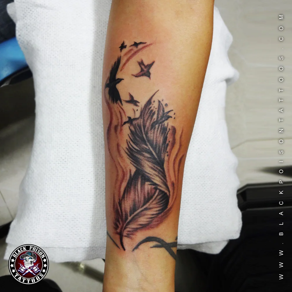Fine line feather tattoo on wrist