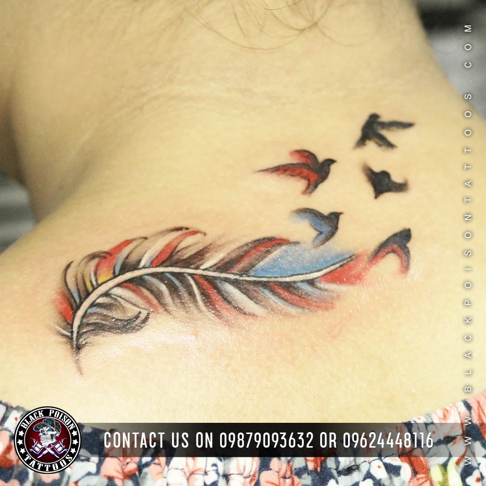 Colourful feather tattoo dissolving into flying birds on the shoulder