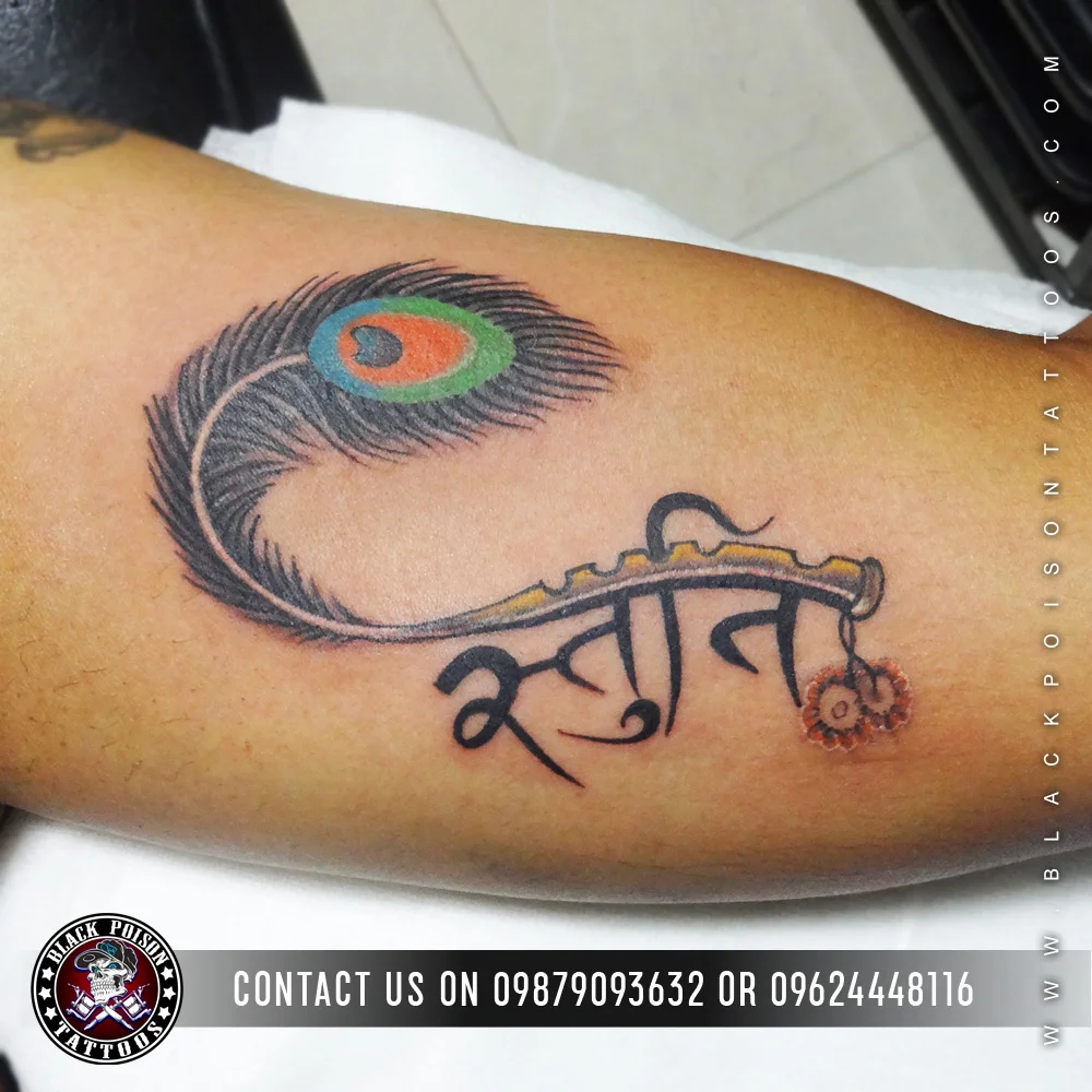 Peacock feather tattoo with a name in Devanagari script on the forearm