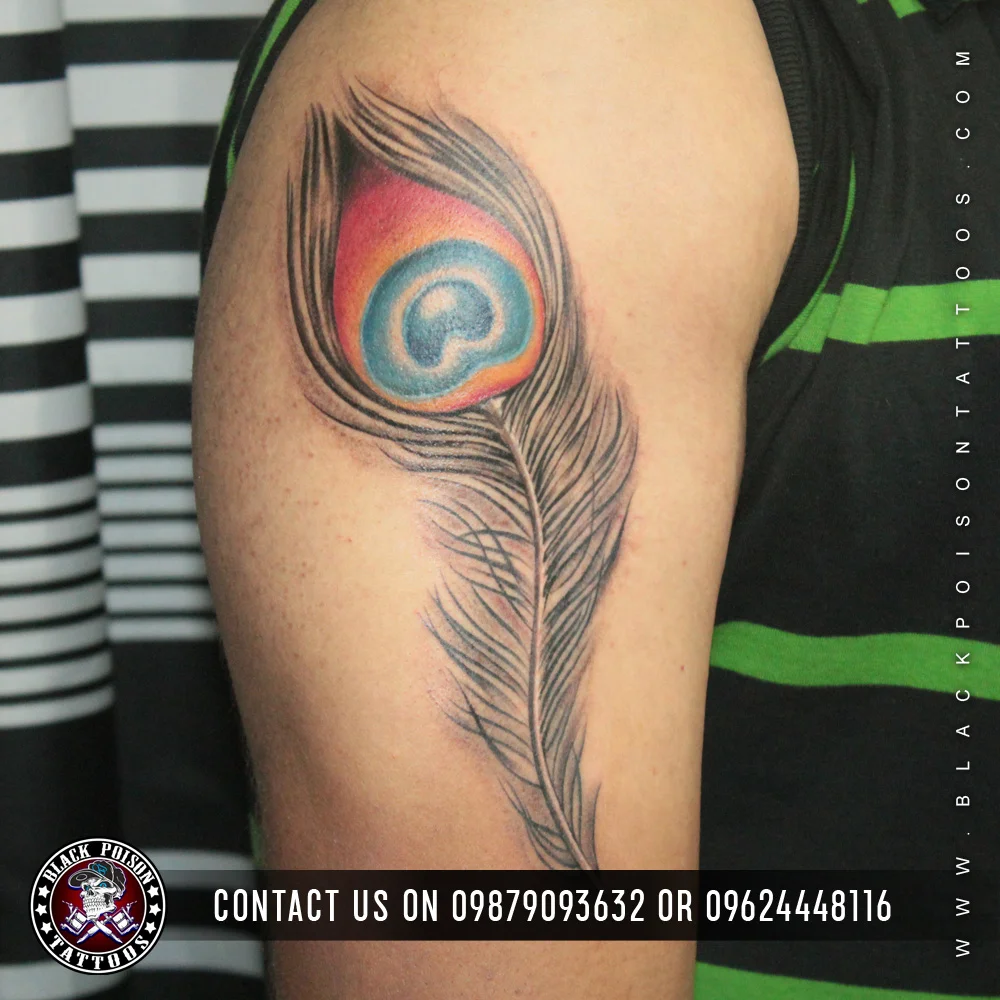 Peacock feather tattoo with a pink eye on the upper arm