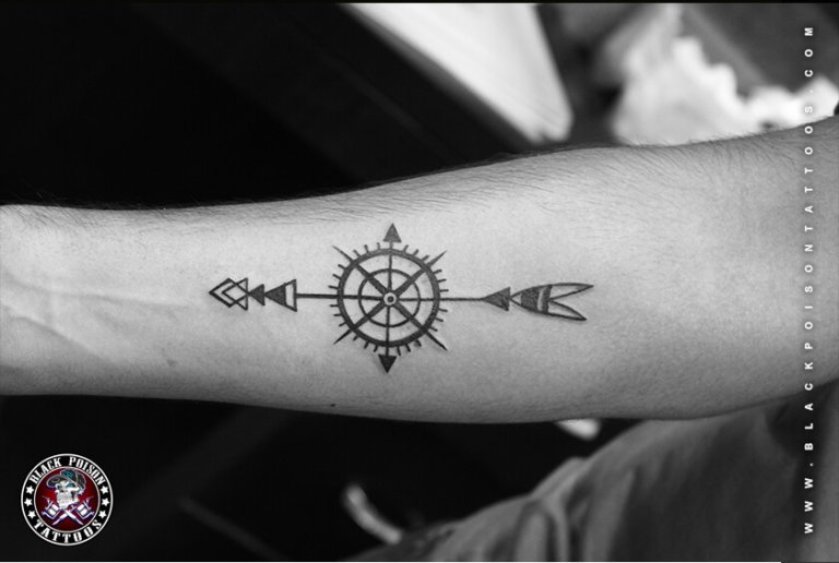 Fine line compass and arrow tattoo on the forearm