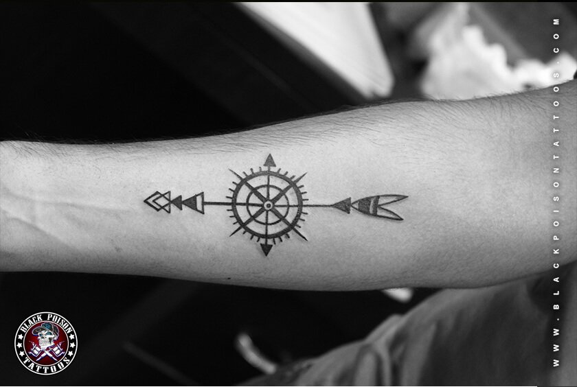 Fine line compass and arrow tattoo on the forearm
