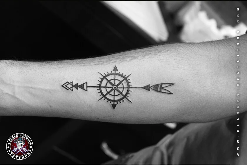 Fine line compass and arrow tattoo on the forearm