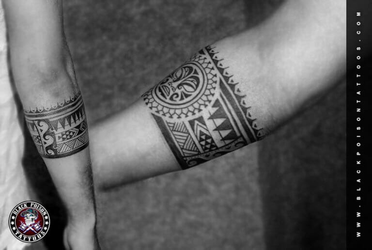 Matching ornamental armband tattoos on two forearms