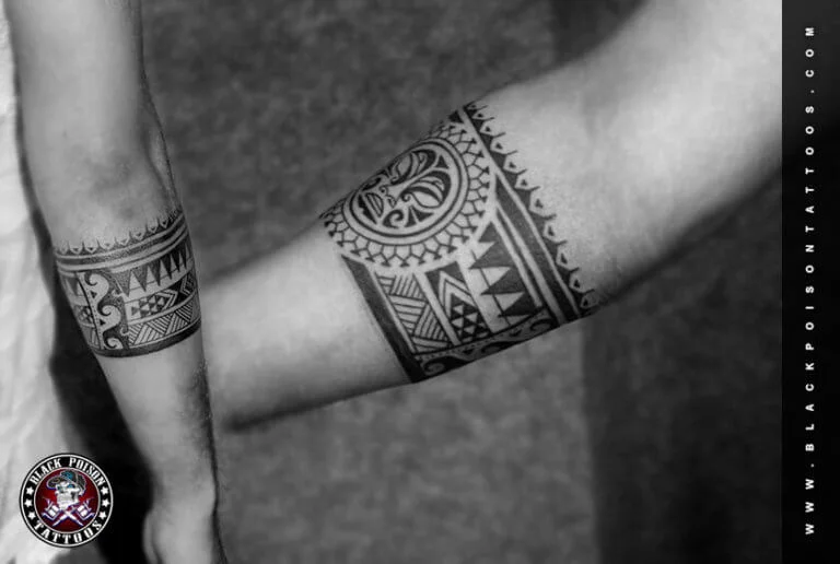 Matching ornamental armband tattoos on two forearms