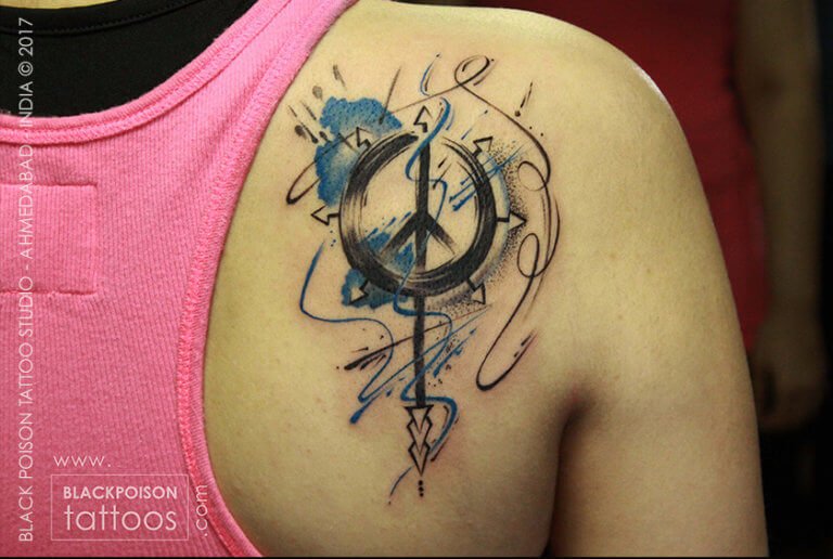 Sikh Khanda emblem tattoo with blue watercolour detail on the shoulder blade