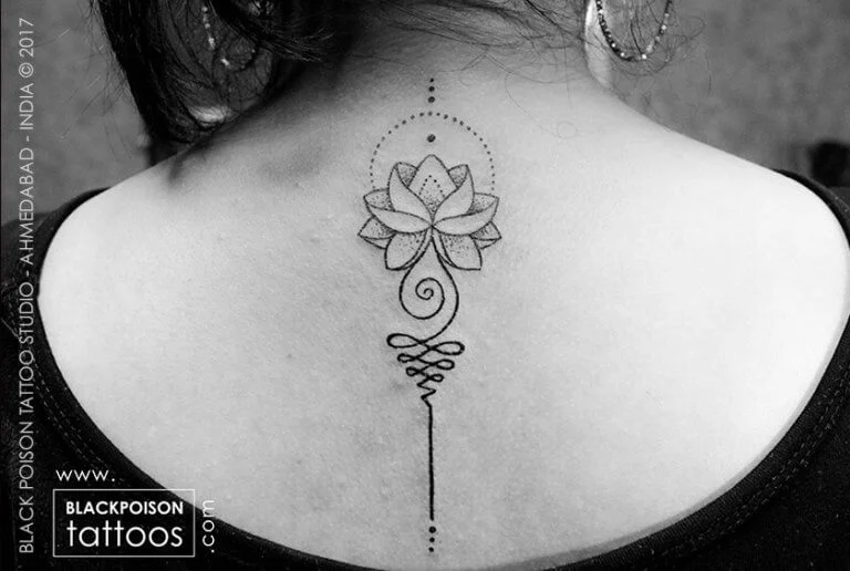 Fine line unalome and lotus tattoo down the spine