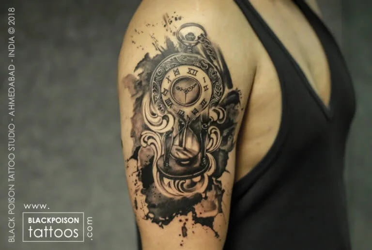 Black and grey ornamental clock and floral tattoo on the shoulder
