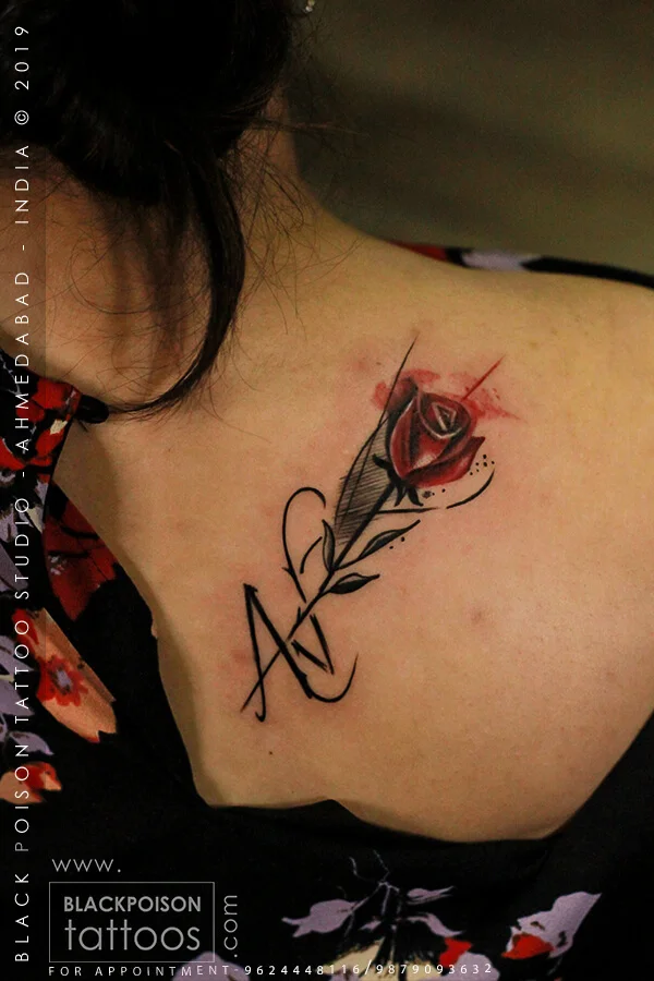 Red rose tattoo with initials on the collarbone