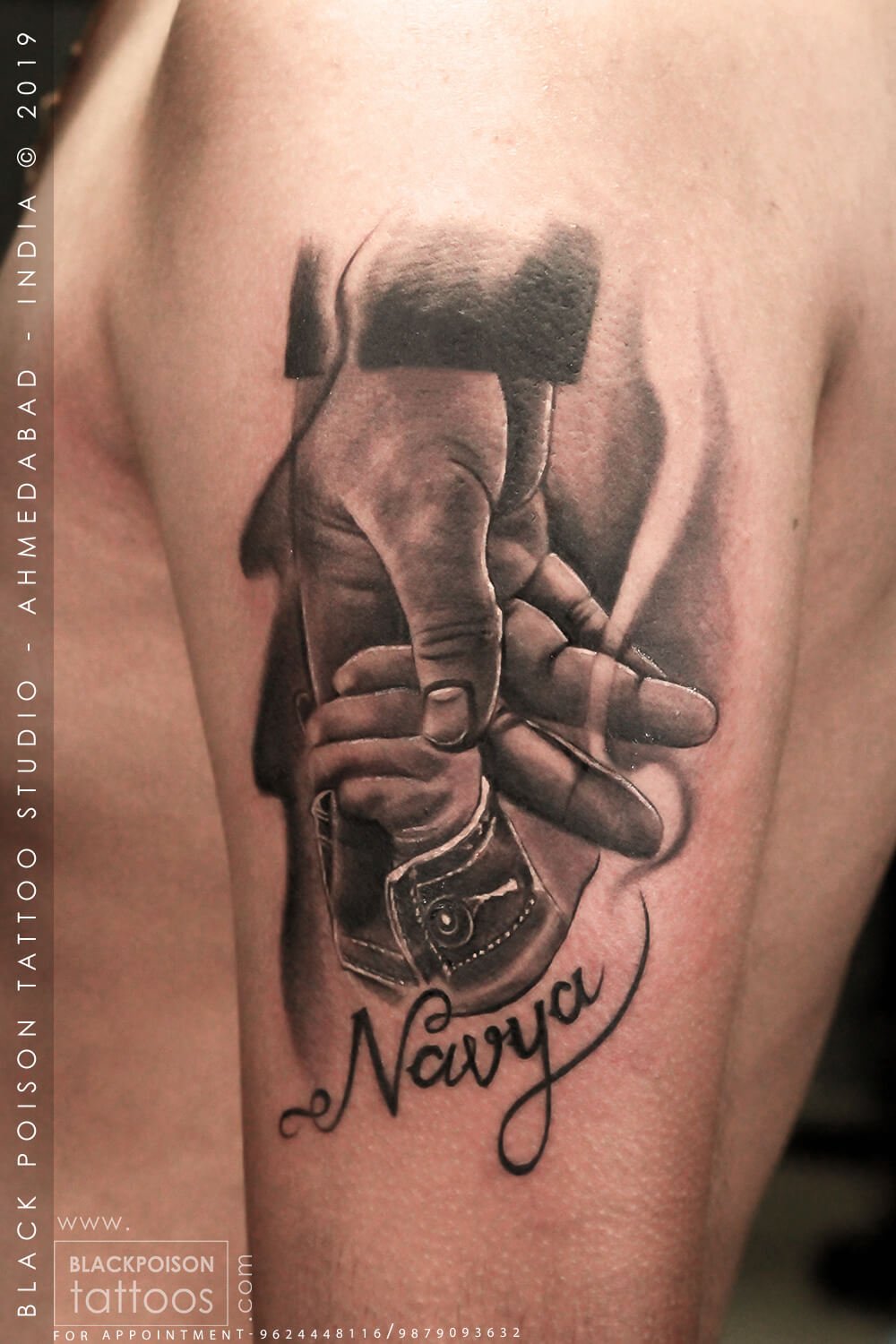 Realistic father and daughter tattoo of an adult hand holding a baby hand with a name in script by Black Poison Tattoo Studio Ahmedabad