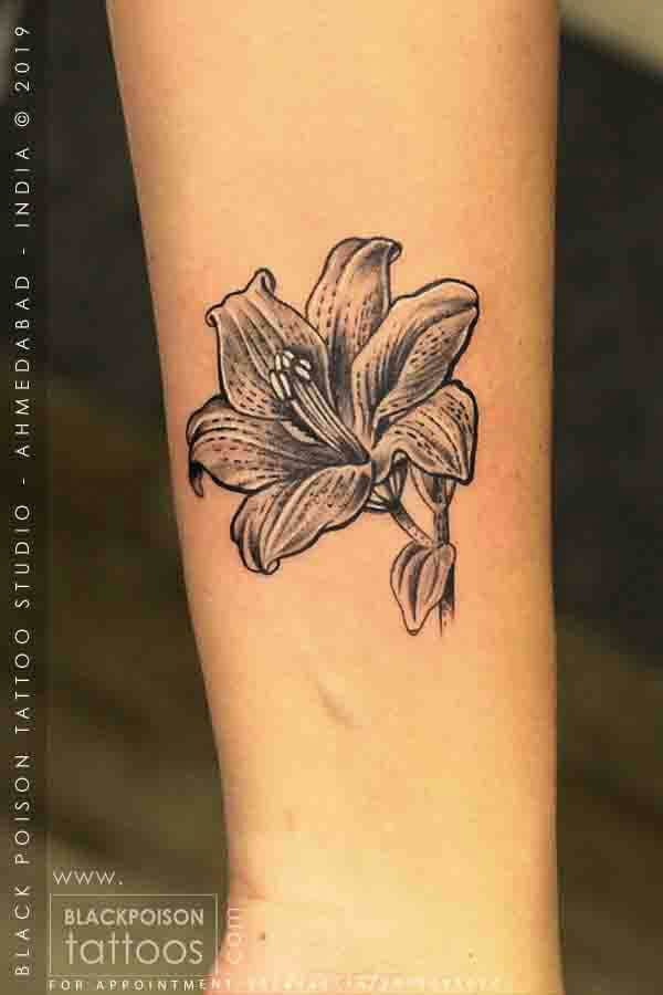 Black and grey lily flower tattoo on the forearm