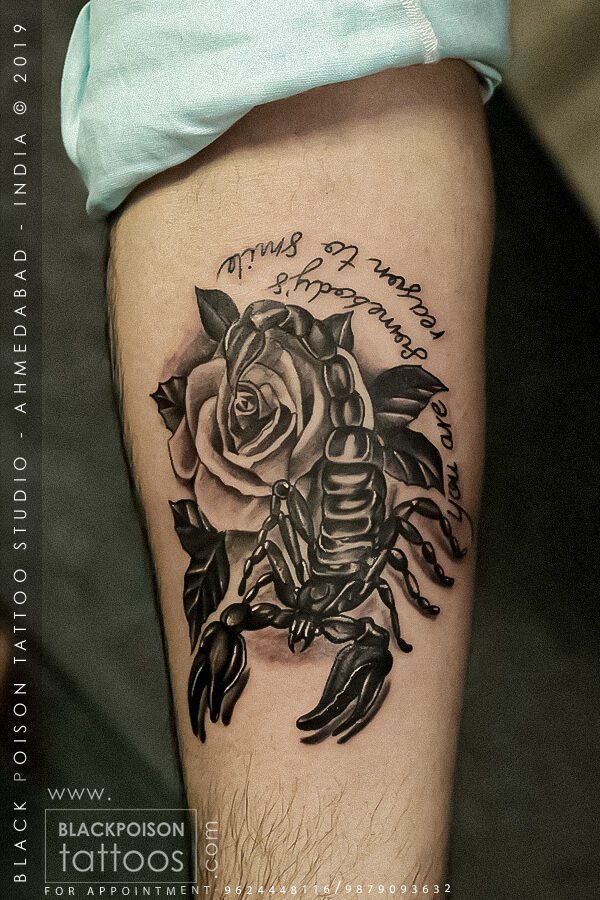 Black and grey scorpion and rose tattoo with script lettering on the thigh by Black Poison Tattoo Studio Ahmedabad