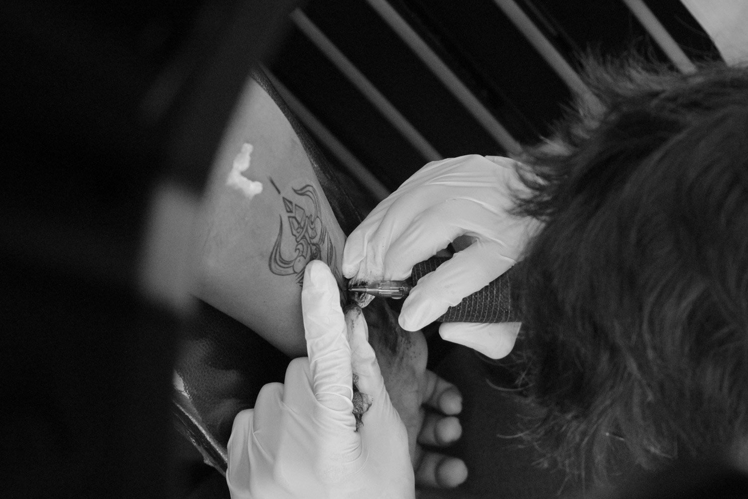 Close up of a piercing being performed on a client's ear