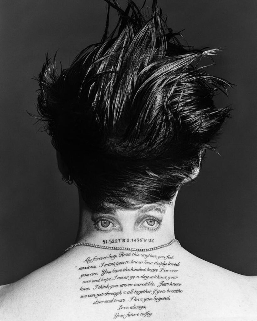 Black and white photograph of Brooklyn Beckham's script passage tattoo across the upper back