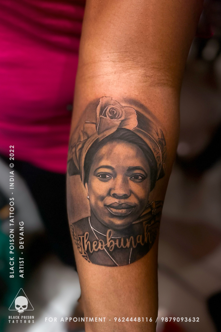 Realistic portrait tattoo of a woman with a head wrap and script lettering on the forearm