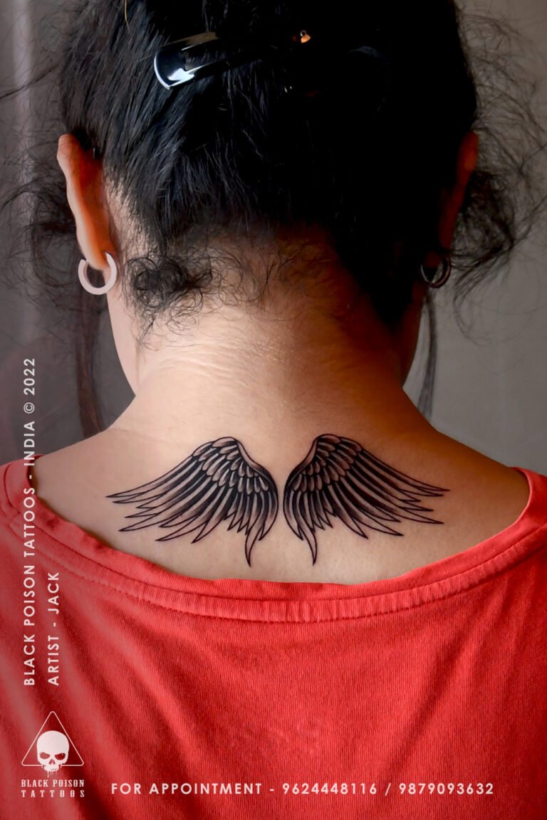 Black and grey angel wings tattoo on the back of the neck