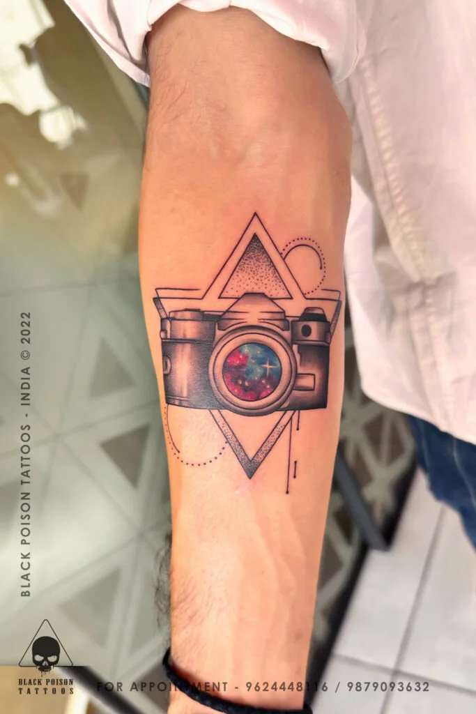 Fine line camera tattoo with a geometric triangle on the forearm