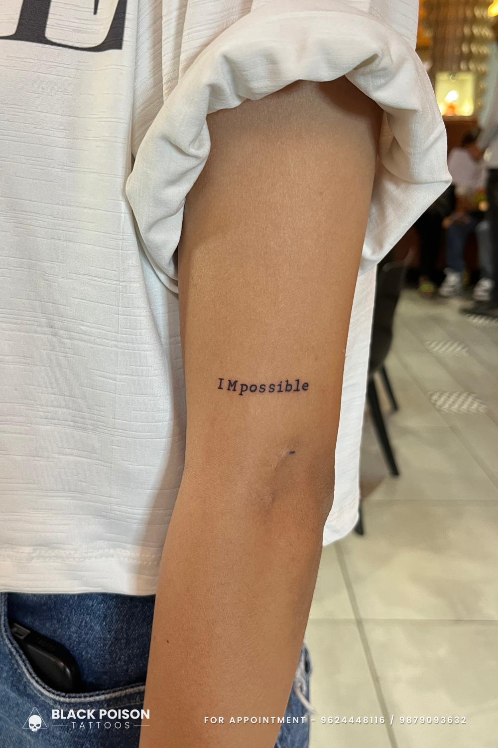 Small script word tattoo on the upper arm
