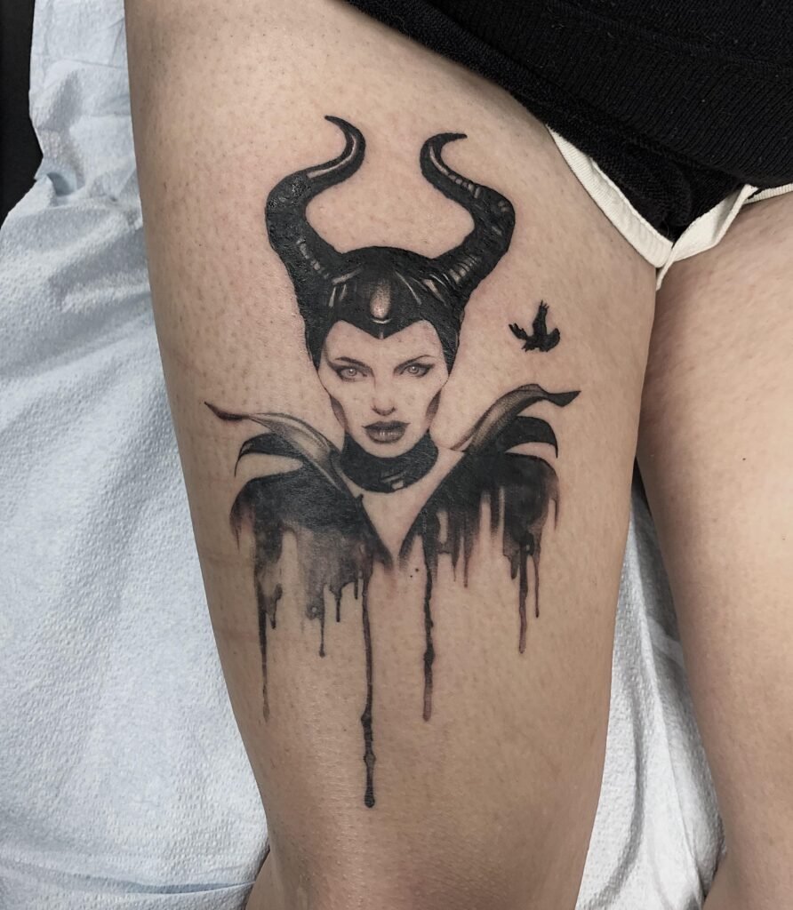 Black and grey Maleficent tattoo with a dripping ink effect on the thigh
