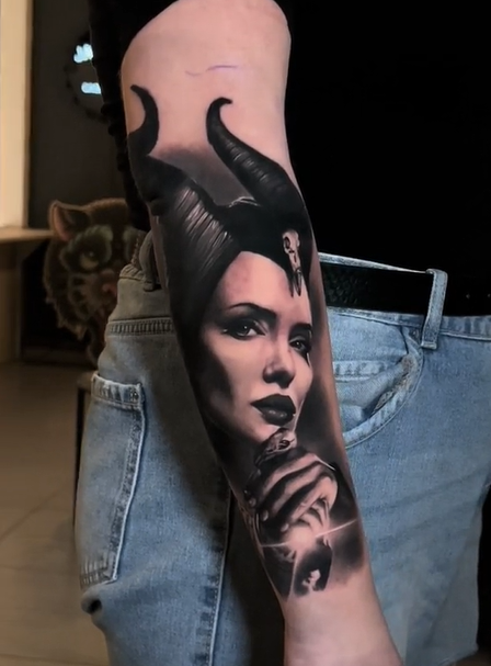 Black and grey realistic Maleficent portrait tattoo on the forearm