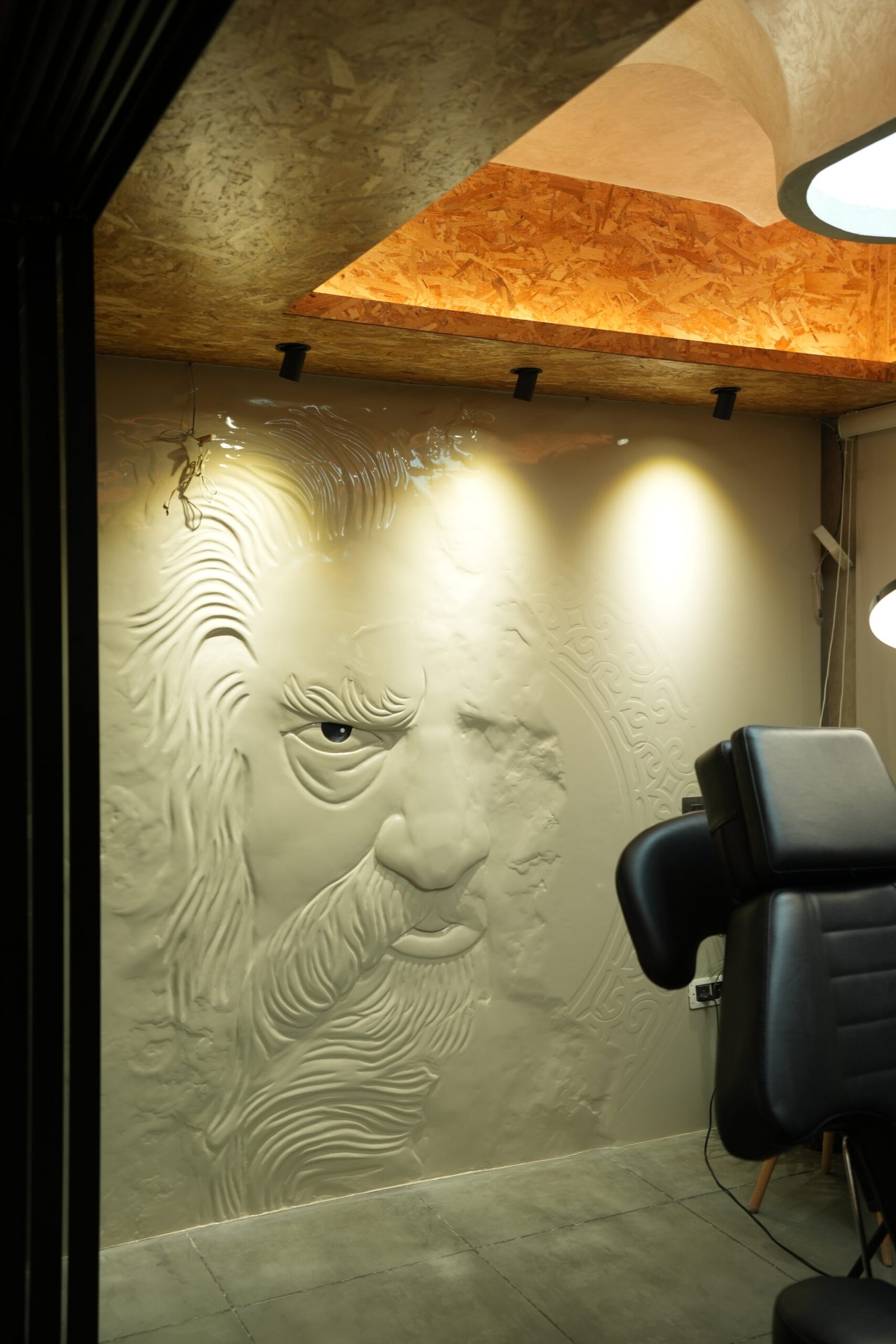 Tattoo room at Black Poison Tattoo Studio with a carved face relief on the wall