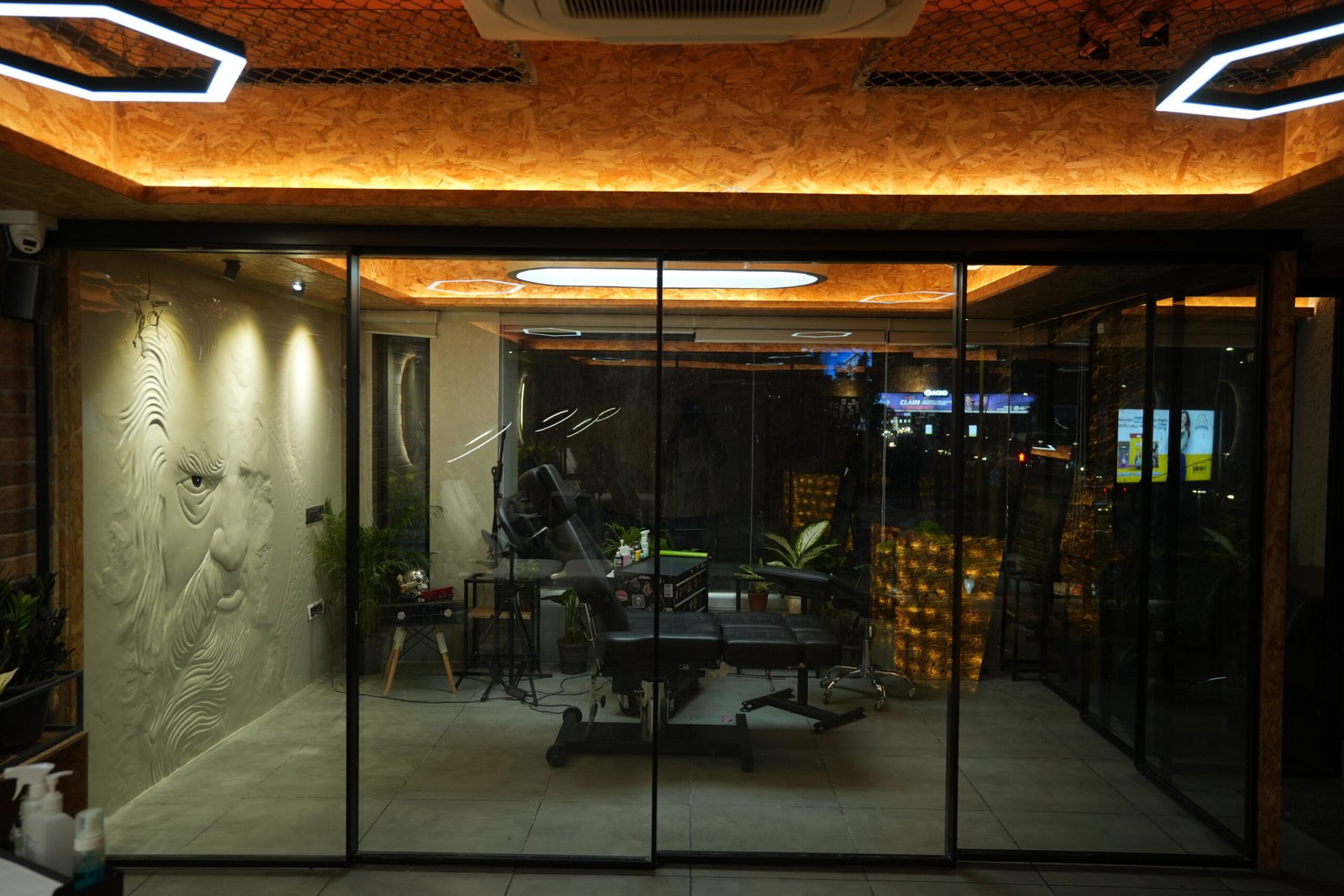Glass frontage of Black Poison Tattoo Studio lit up at night