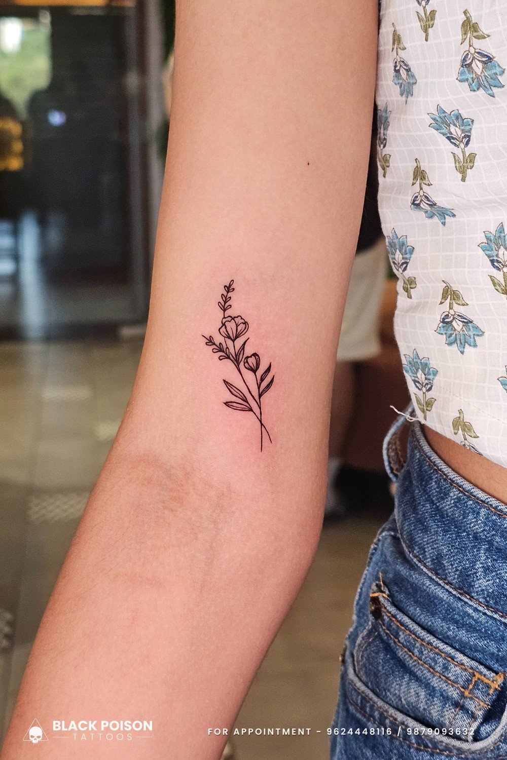 Minimal floral fine line tattoo on inner arm by Black Poison Tattoo Studio Ahmedabad