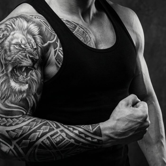 A powerful, custom black and grey realism chest and half-sleeve tattoo designed for men by Black Poison Tattoo Studio in Ahmedabad.