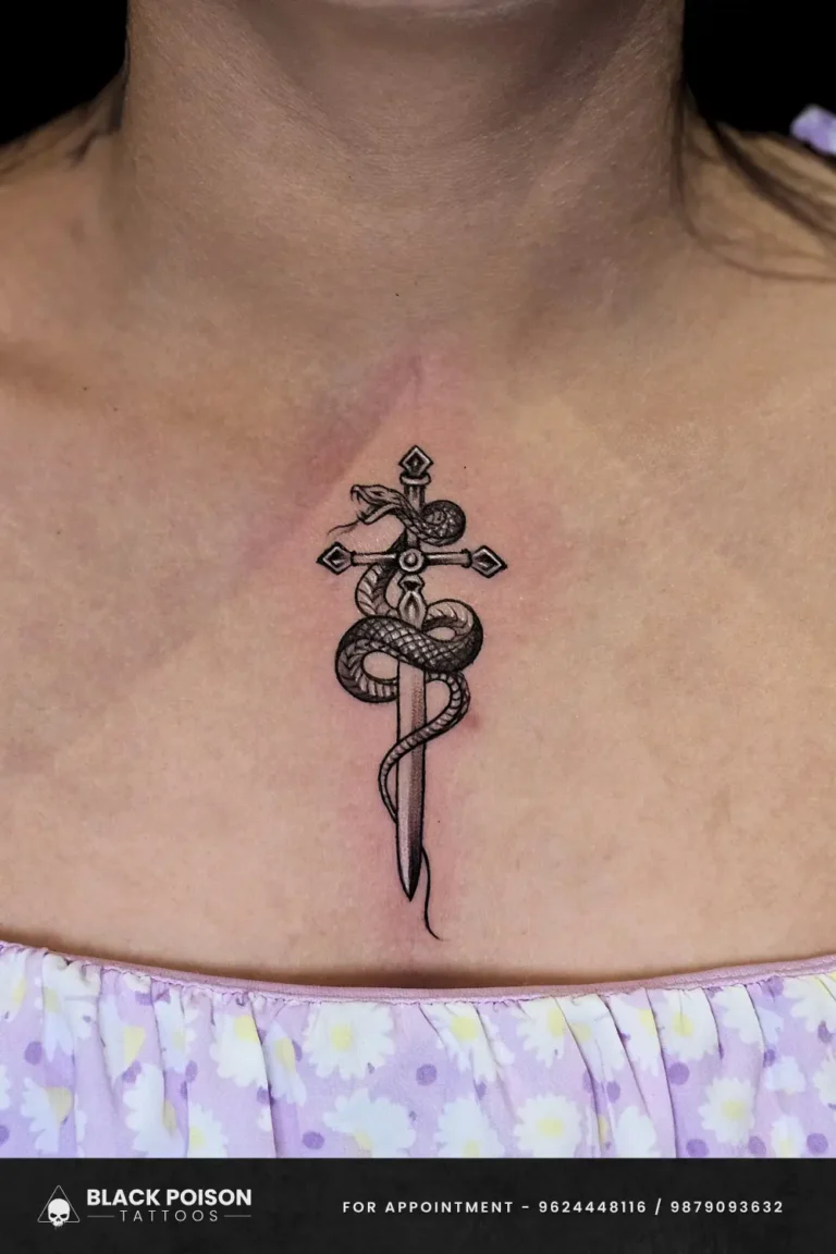 Black and grey illustrative snake coiled around a dagger tattoo on a woman's sternum, done at Black Poison Tattoo Studio in Ahmedabad.