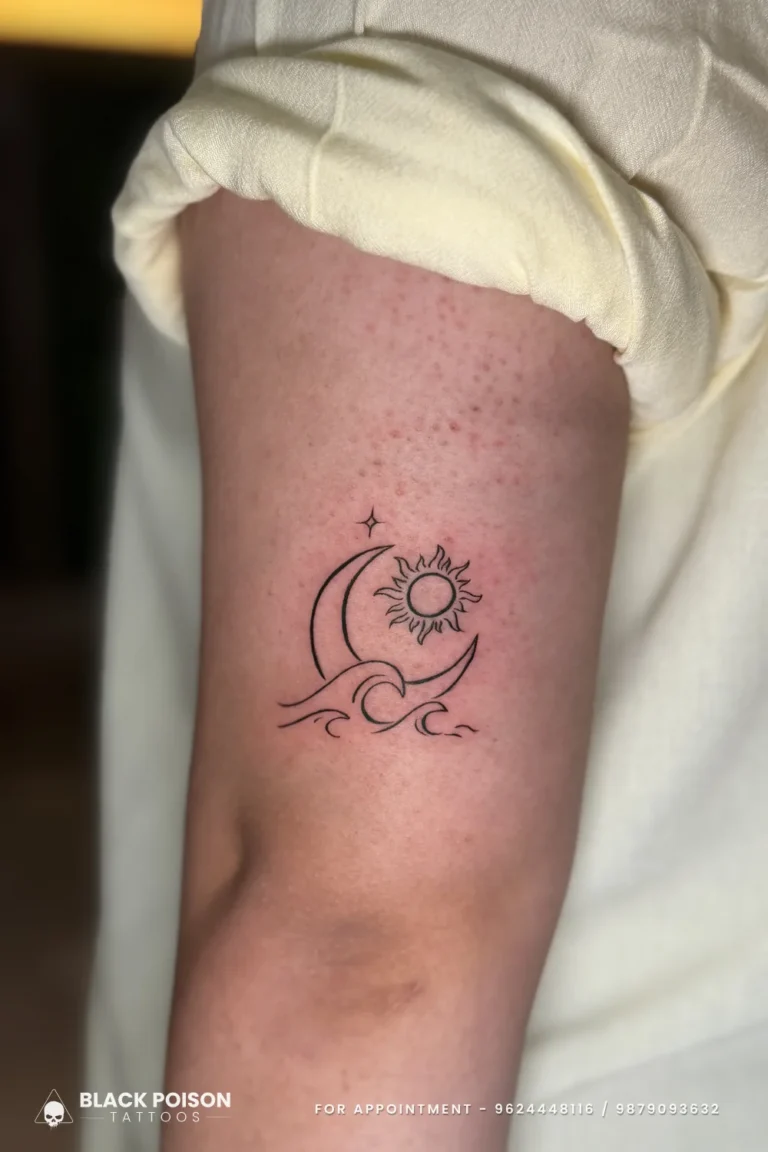 Fine line black crescent moon, sun and wave tattoo on the back of the upper arm at Black Poison Tattoo Studio, Ahmedabad