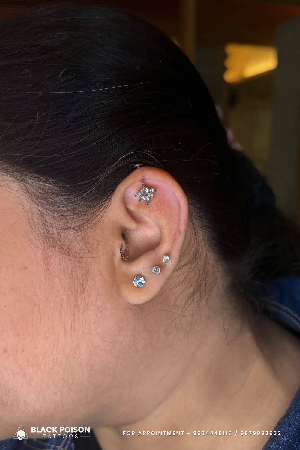 Curated ear with a crystal cluster on the upper cartilage, a small tragus ring and three graduated crystal lobe studs