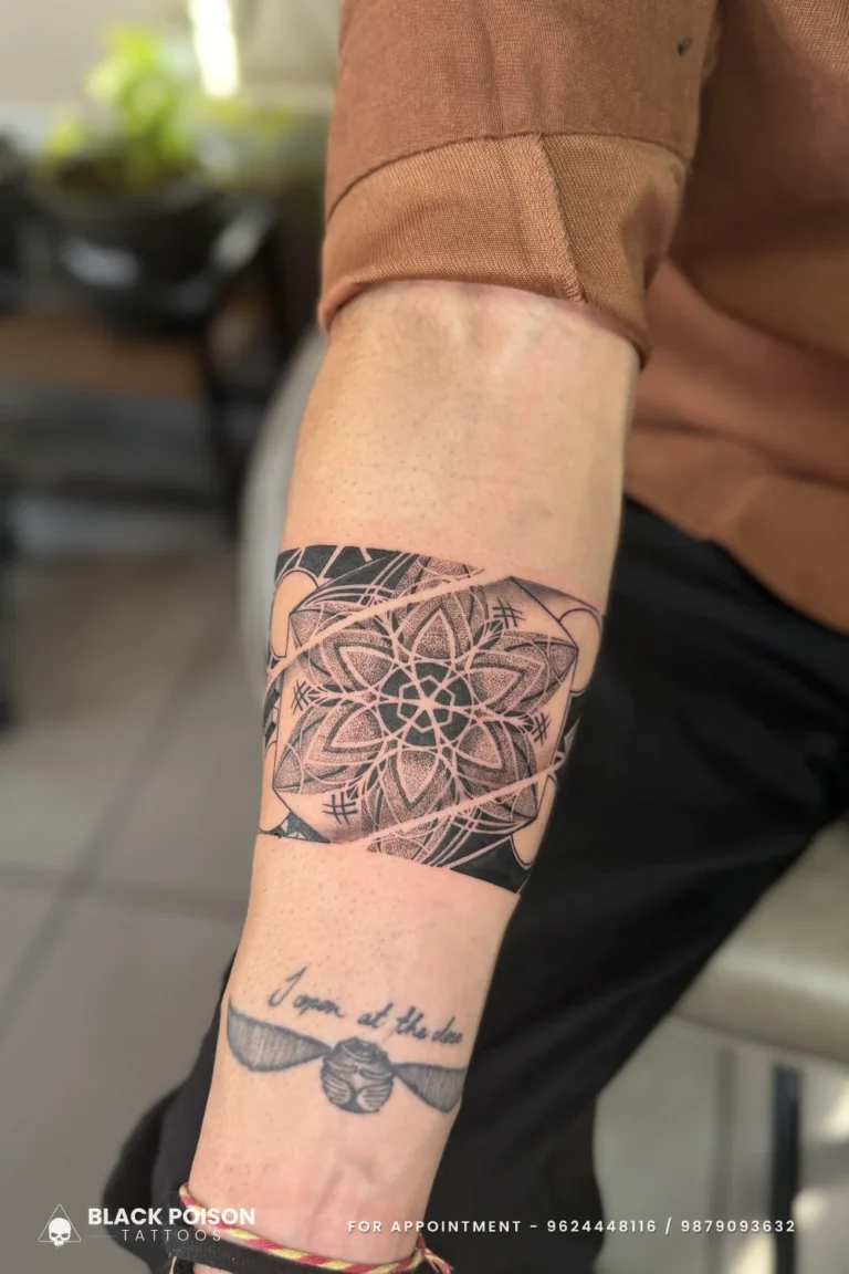 Dotwork mandala armband tattoo with a stippled flower and black edges on the forearm at Black Poison Tattoo Studio, Ahmedabad