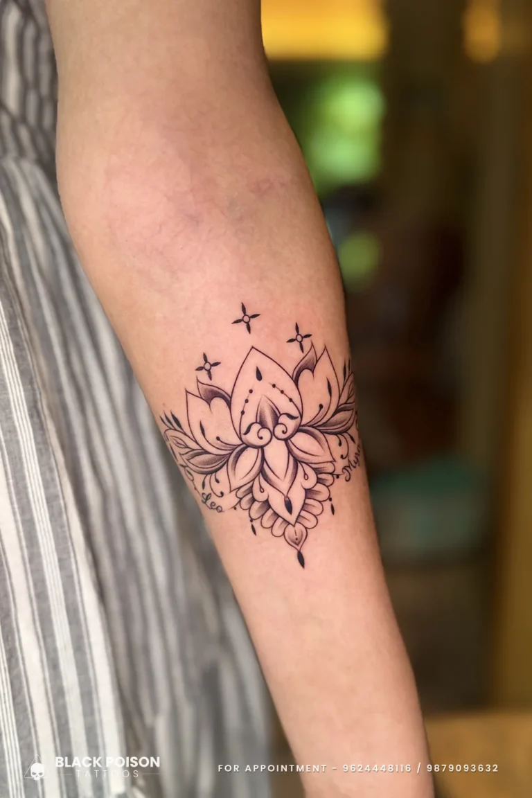 Fine line lotus tattoo with ornamental base and sparkle stars on the forearm at Black Poison Tattoo Studio, Ahmedabad