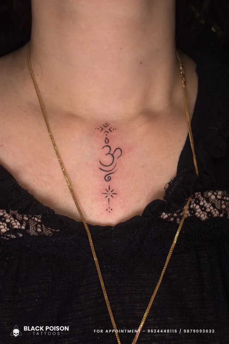 Fine line black Om tattoo with ornamental dots and lotus flourish on the sternum at Black Poison Tattoo Studio, Ahmedabad