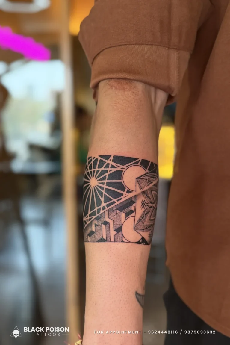 Geometric blackwork armband tattoo with negative-space lines on the forearm at Black Poison Tattoo Studio, Ahmedabad