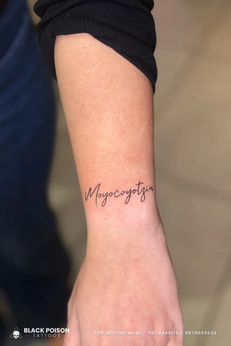 Cursive Moyocoyotzin script tattoo in fine line black on the inner wrist at Black Poison Tattoo Studio, Ahmedabad