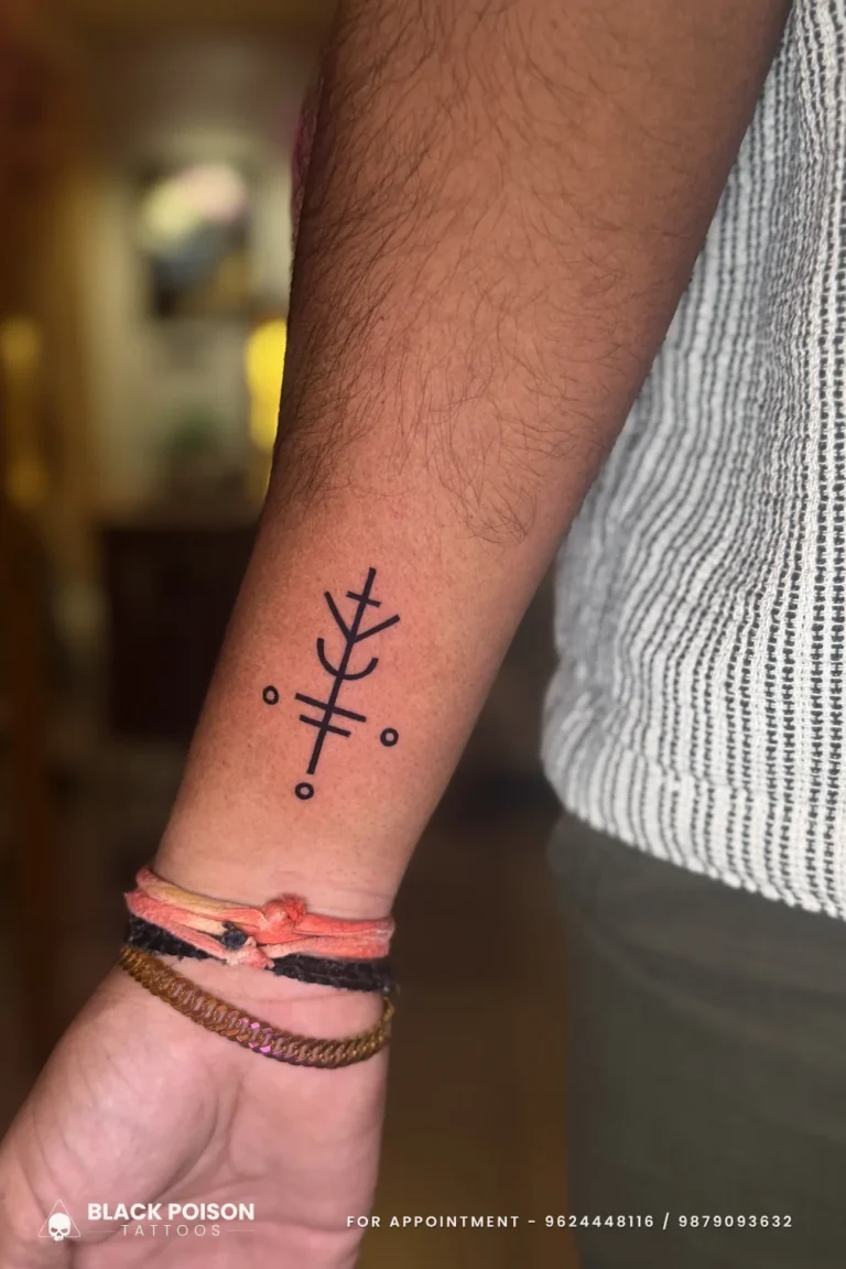 Bold black Nordic bindrune stave tattoo on the outer forearm above the wrist at Black Poison Tattoo Studio, Ahmedabad