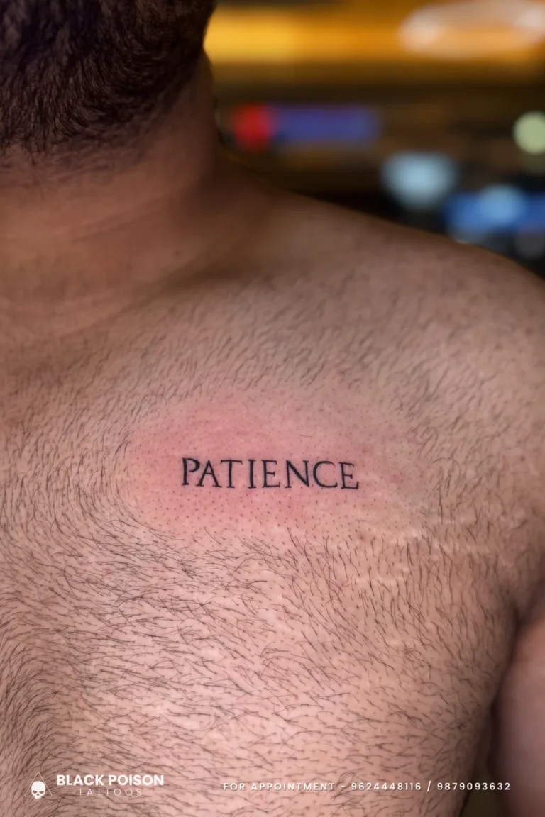 The word PATIENCE tattooed in small black serif capitals across the centre of the chest at Black Poison Tattoo Studio, Ahmedabad