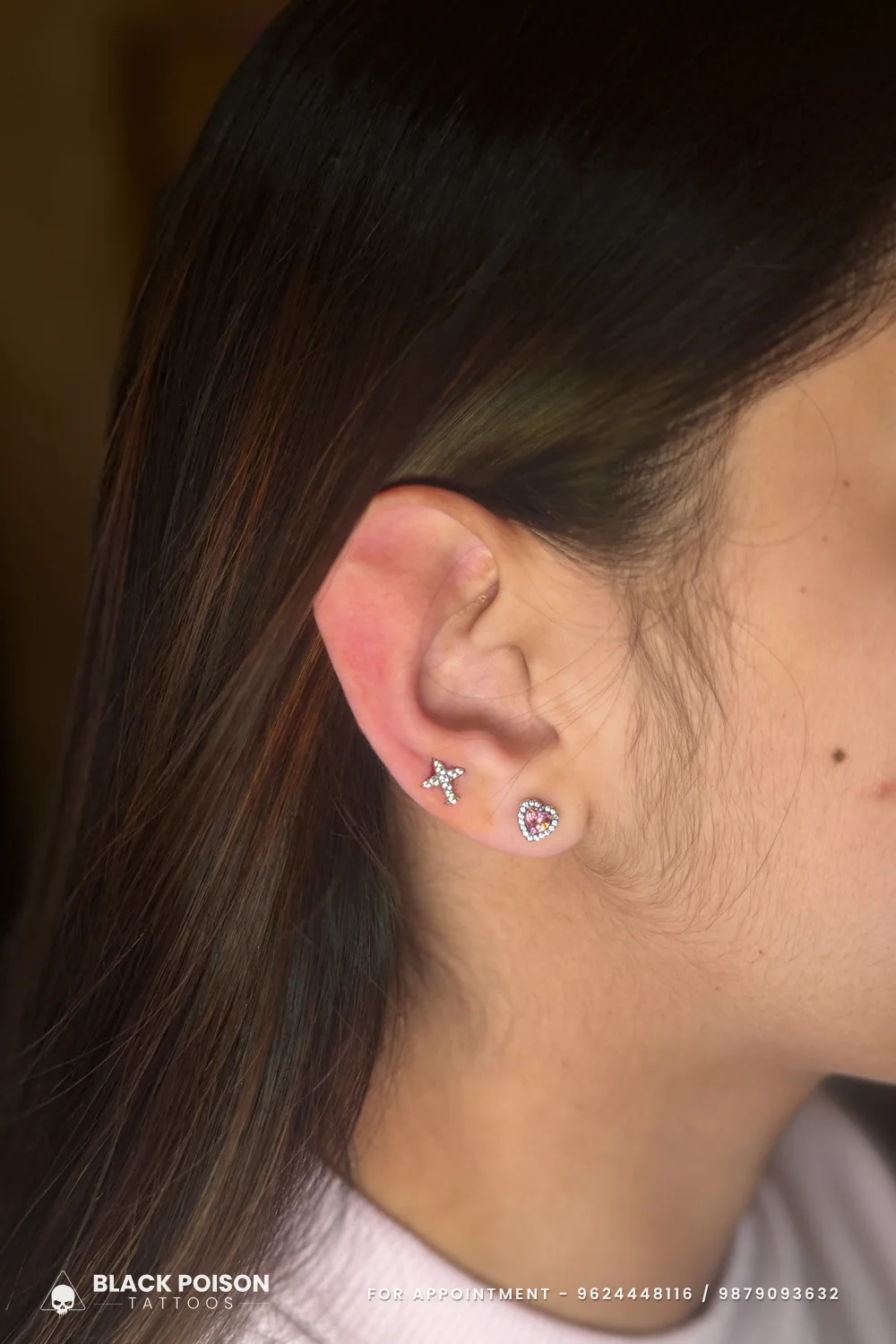 The other ear of the same client with a jewelled heart stud and a small crystal cross stud stacked on the lobe