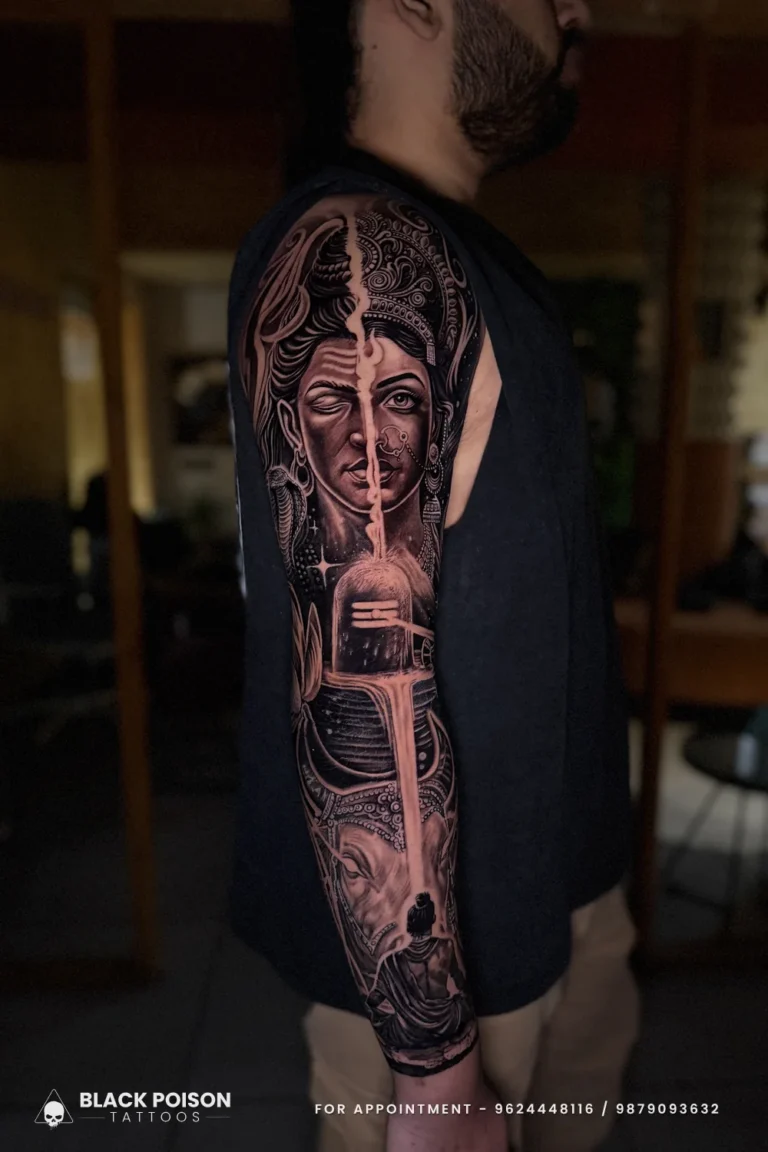 Black and grey realism sleeve with a split Shiva Parvati face, Shivling and Nandi at Black Poison Tattoo Studio, Ahmedabad