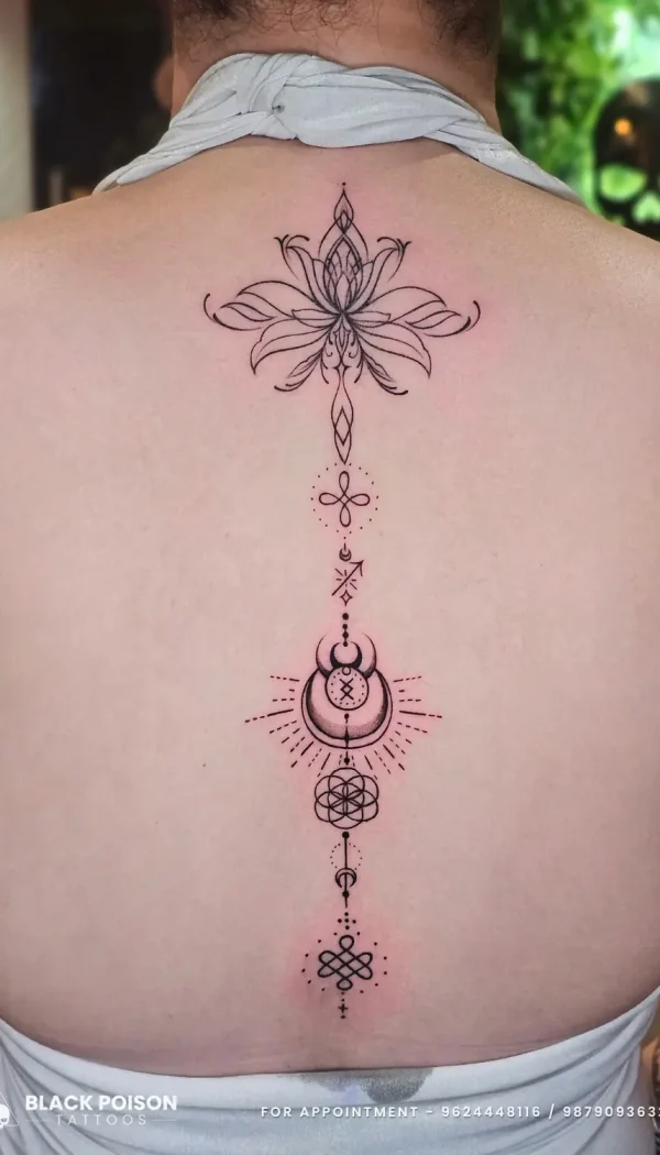 A custom fine line ornamental spine tattoo for women featuring an unalome, lotus, and sacred geometry, crafted at Black Poison Tattoo Studio in Ahmedabad.